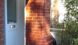 Door pillar looking somewhat better following expert brick restoration, re-profiling and tinting.