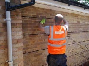 Inserting helical bar to repair cracks in wall